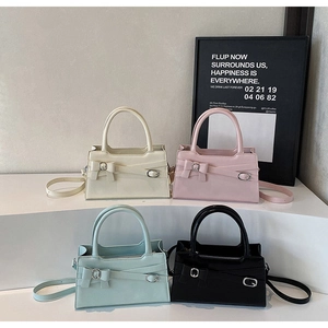 Collection of four bow-decorated shoulder bags in beige, pink, green, and black