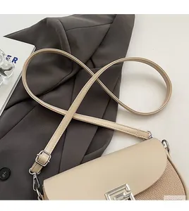 Detail of beige saddle bag showing leather and woven fabric texture with silver buckle