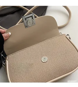 Detailed shot of woven crossbody bag with silver metal buckle and premium texture