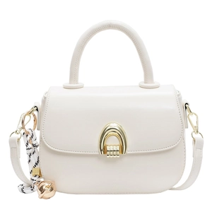 Chic beige leather crossbody saddle bag with gold horse-bit buckle and braided pendant