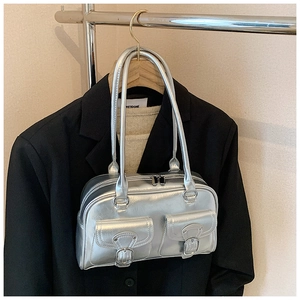 Detailed view of silver metallic pillow bag featuring dual front pockets and Y2K aesthetic