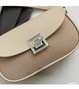 Close-up of woven fabric and smooth leather patchwork with a silver geometric lock