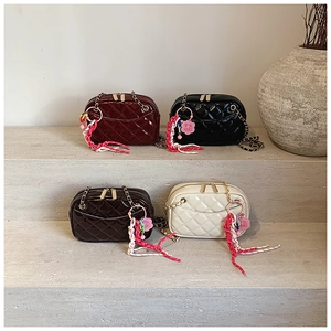 Close-up of four quilted crossbody bags with metal chains and tassel floral charms