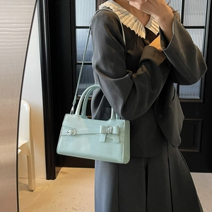 Chic light blue leather crossbody bag with bow detail and elegant top handles for women