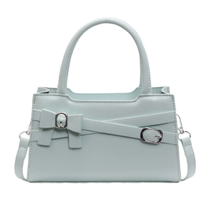 Minimalist light blue crossbody bag with leather bow and detachable strap on white background
