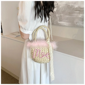 Detail of woven straw bucket bag with pink feathers, Moe embroidery and pearl strap