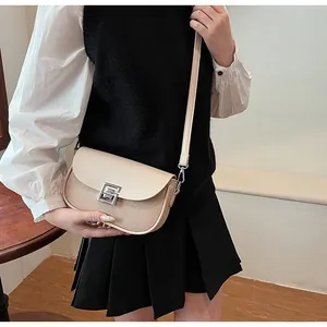 Detail of beige crossbody bag with straw woven texture and silver square metal lock
