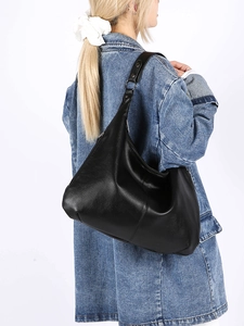 Détail du sac hobo noir à grain litchi avec anneaux métalliques argentés et bandoulière