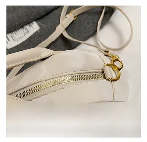Détail du sac bowling blanc cassé avec crochets en métal doré et fermeture éclair