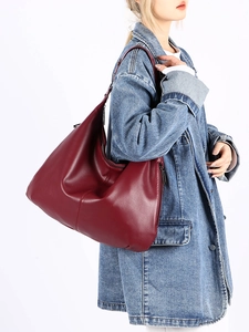 Vue détaillée du grand sac hobo rouge vin en cuir souple porté par un mannequin