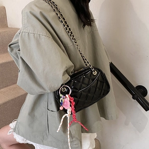 Chic black quilted crossbody bag with gold chain strap and colorful woven charm