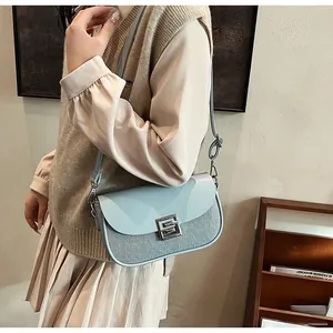 Close-up of light blue leather and woven texture mix on shoulder bag with silver buckle