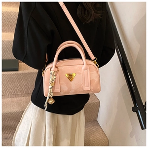 Vue détaillée du sac bowling en cuir rose avec logo doré et ornement de foulard imprimé