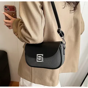 Detail of minimalist black leather flap and grey textured body with silver square buckle