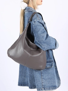 Vue latérale d'un sac hobo en cuir gris foncé à grain de litchi porté par un mannequin