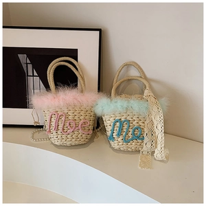 Detail of woven straw bucket bag with delicate feather trim and pearl strap accents