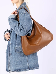 Détail d'un sac hobo marron en cuir grainé avec fermeture éclair métallique pour le quotidien
