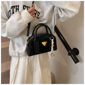Vue détaillée d'un mini sac bowling noir brillant avec finitions dorées et foulard en soie