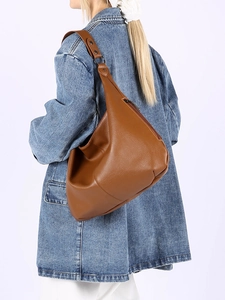 Gros plan d'un sac hobo en cuir marron à motif litchi avec large bandoulière et zip