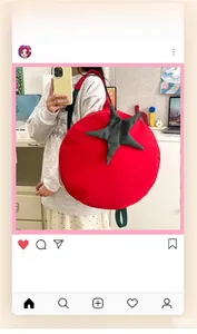 Detail of creative tomato-shaped backpack with green leaf accents on a female model