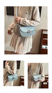 Detail of light blue crossbody bag with woven texture and square silver metal buckle