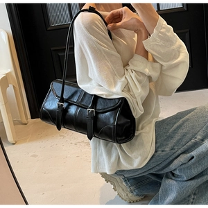 Detailed close-up of a black retro underarm bag with silver buckles and faux leather texture