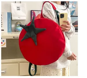 Detailed view of creative tomato-shaped red canvas backpack with green star-shaped accents