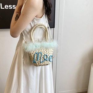 Chic woven straw bucket bag with green feather trim and pearl shoulder strap for women
