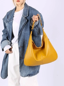Gros plan d'un sac hobo jaune en cuir grainé porté par un mannequin pour le quotidien