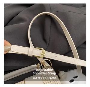 Detail showing adjustable white leather strap with golden buckle on woven bag