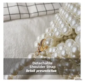 Detail view of glossy white pearl beads with a golden detachable metal lobster clasp strap