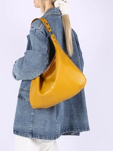 Détail du sac Hobo jaune en cuir grainé avec bandoulière large et rivets argentés