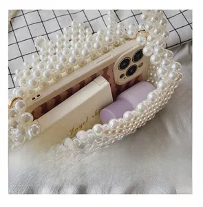 Detail showing the internal capacity of the pearl beaded handbag for phone and makeup