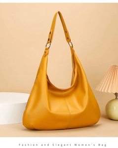 Détail d'un sac cabas jaune vif en cuir grainé avec une forme de demi-lune élégante