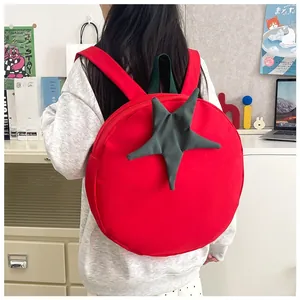 Close-up of a creative red tomato-shaped backpack worn by a model in a cozy study room