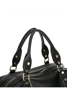 Detail of black pebbled leather handbag with gold hardware rivets and sturdy dual handles