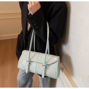 Detail view of a light blue glossy shoulder bag with silver buckle and thin straps