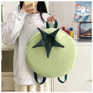 Detail of cute tomato shaped backpack in light green with 3D star stem and green straps