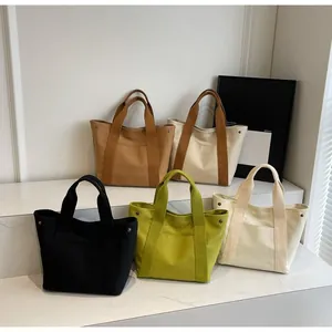 Detailed view of the five color variations of the canvas tote bag with metal hardware
