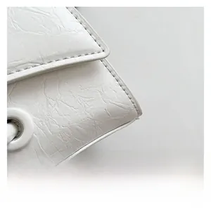 Detailed macro view of white textured leather stitching and round metal eyelet buckle