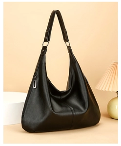 Détail du sac hobo en cuir noir avec fermeture éclair latérale et couture verticale