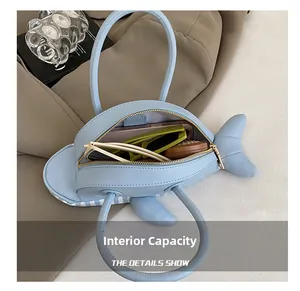 Detail view showing interior capacity of a light blue shark shaped shoulder bag