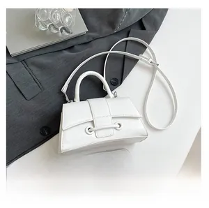 Detailed close-up of white crocodile pattern handbag with phone for size comparison