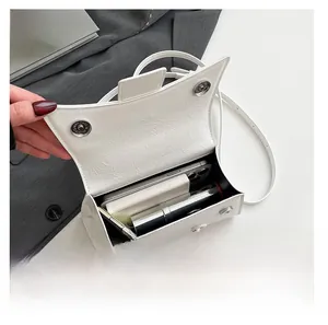Interior capacity of the white textured hourglass bag showing phone and essentials