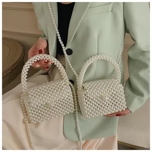 Detail of handmade pearl woven handbag with glossy beads and crossbody strap chain