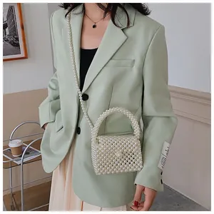 Detailed view of handmade white pearl woven handbag with beaded handle and shoulder strap