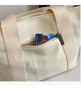 Detailed close-up of canvas tote bag side pocket with a durable metal zipper