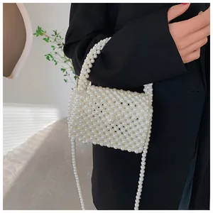 Detailed shot of handmade pearl beaded handbag with flap and crossbody chain strap