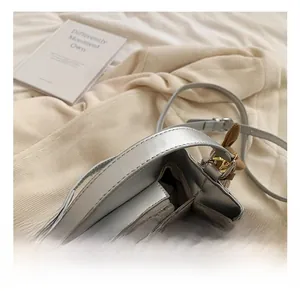 Close-up of silver woven bucket bag showing the interior compartment and metal handle