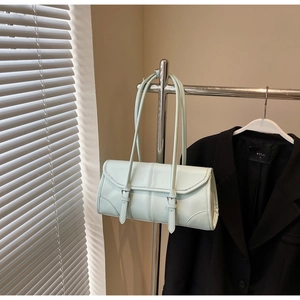 Detail of mint green rectangle underarm bag with slim buckle straps and glossy PU leather